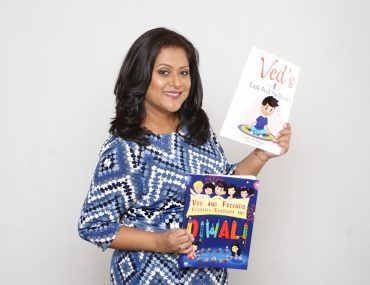 A women posing and smiling with books in hand